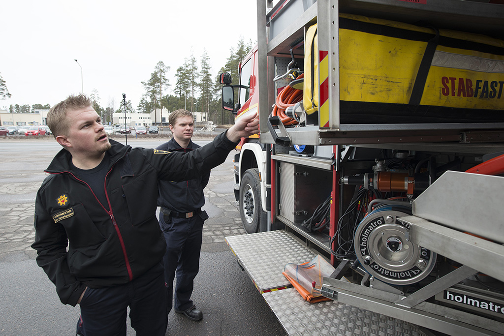 Vuoromestari Mikko Saastamoinen esittelee liikenneonnettomuuksiin erikoistunutta raivausautoa. Taustalla palomies Henri Häkkinen.