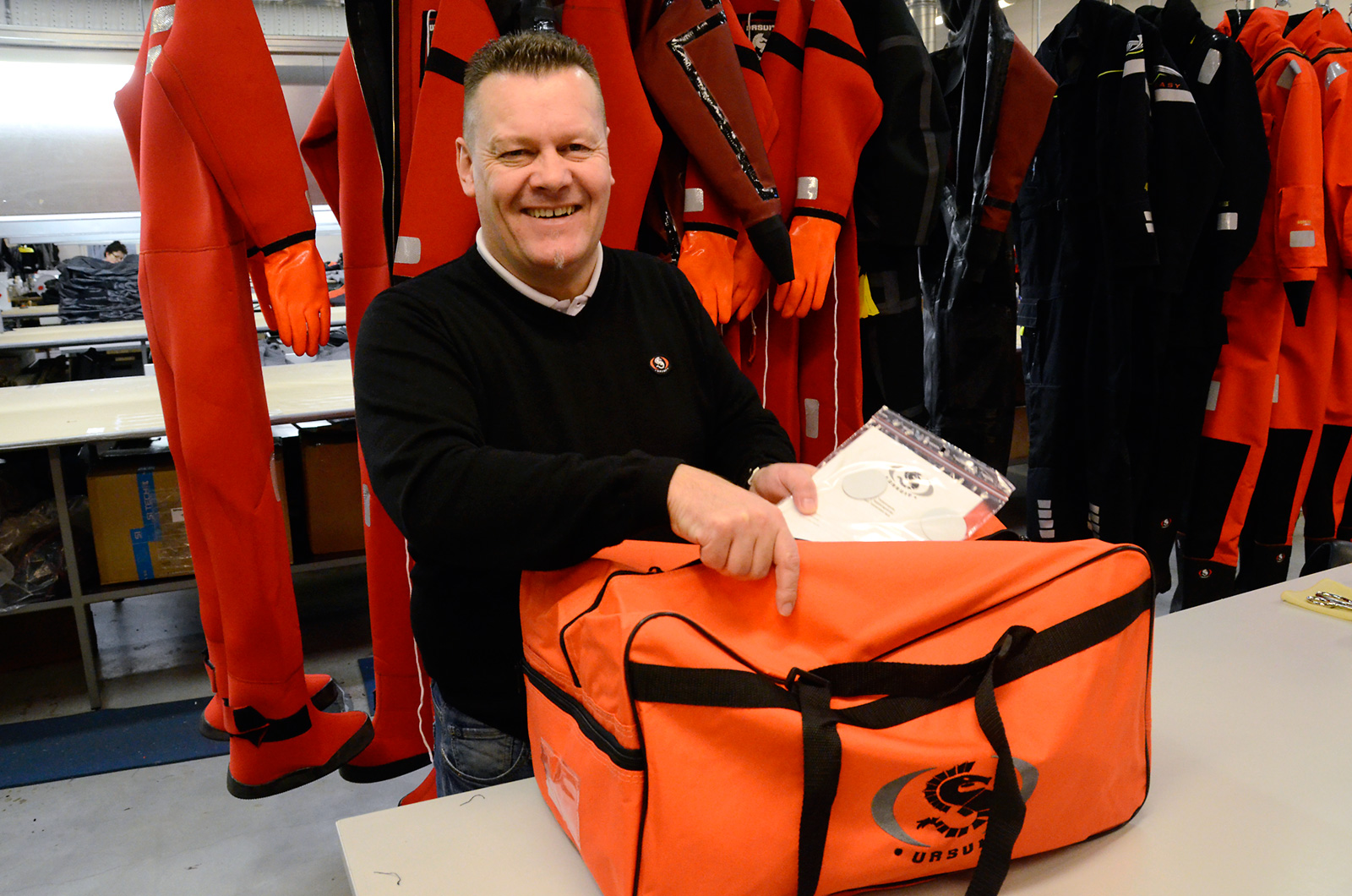 Ursuk Oy:n kotimaan myyntipäällikkö Lassi Lindstedt pakkaa kassiin valmiin pelastuspuvun ohjeineen.
