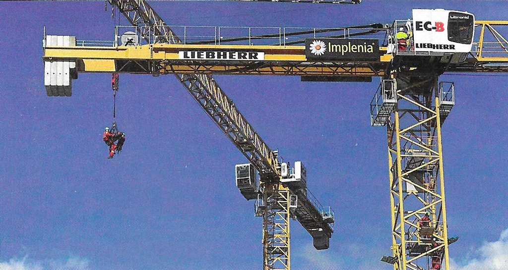 Köysipelastajat laskivat koppiinsa lyyhistyneen nosturinkuljettajan 30 metrin korkeudesta maanpinnalle. Kuvakaappaus: Feuerwehr-Magazin 12/2021.