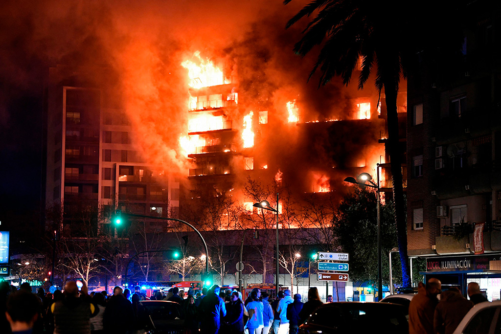Ihmiset kerääntyivät ihmettelemään epäuskoisina tulessa riehuvaa asuinkerrostaloa.