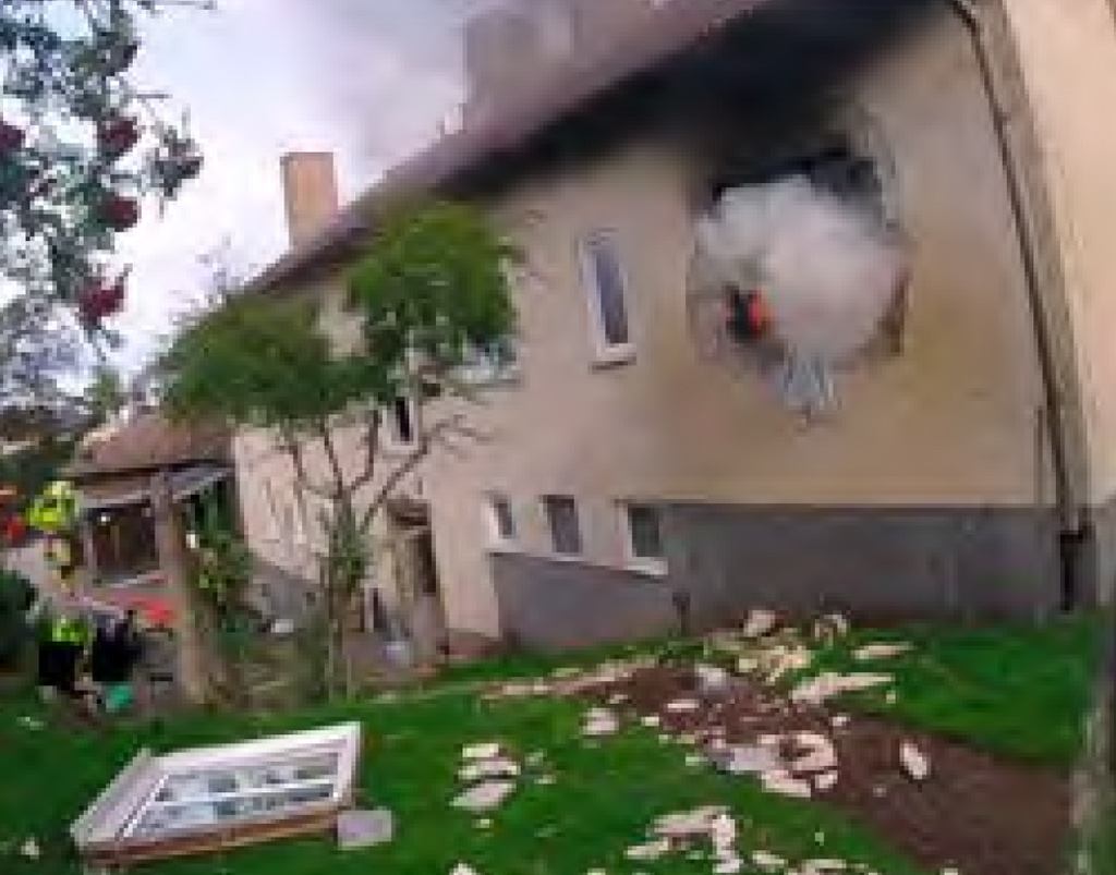 Makuuhuoneen ikkuna karmeineen oli lentänyt pihalle ja aukosta nousi savua. Kuvakaappaus: Tjugofyra7, 62/2024.
