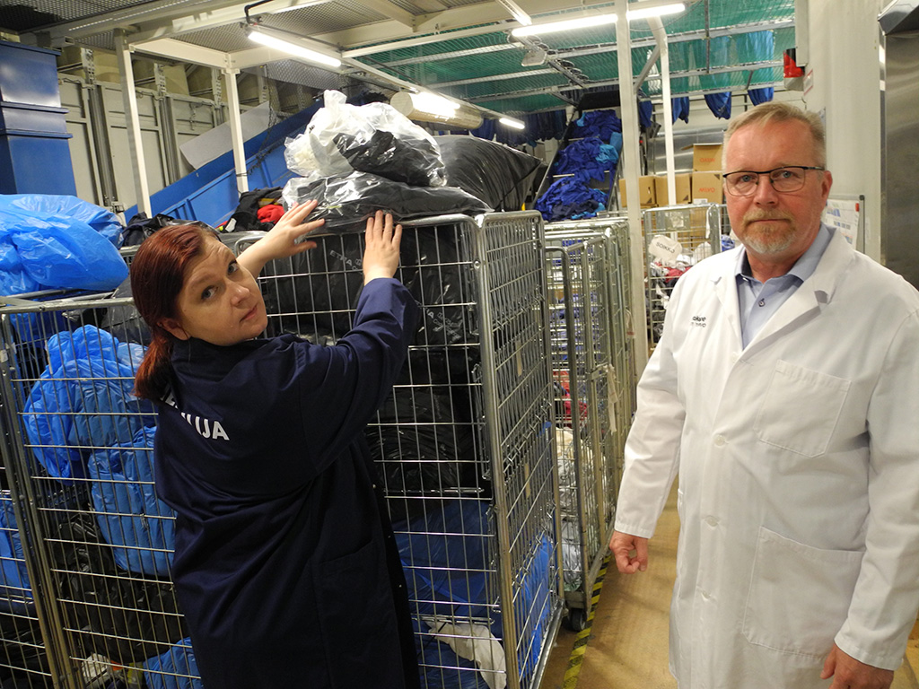 Palveluesimies Tanja Rautiainen ja toimitusjohtaja Antti Tervo sekä rullakko pestäviä tekstiilejä.